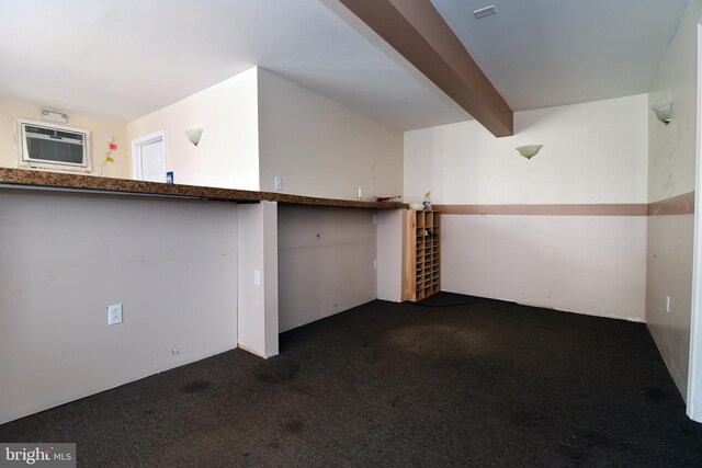 interior space with beam ceiling, dark colored carpet, and a wall mounted air conditioner