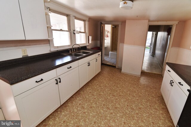 kitchen with white cabinets, sink, and tasteful backsplash