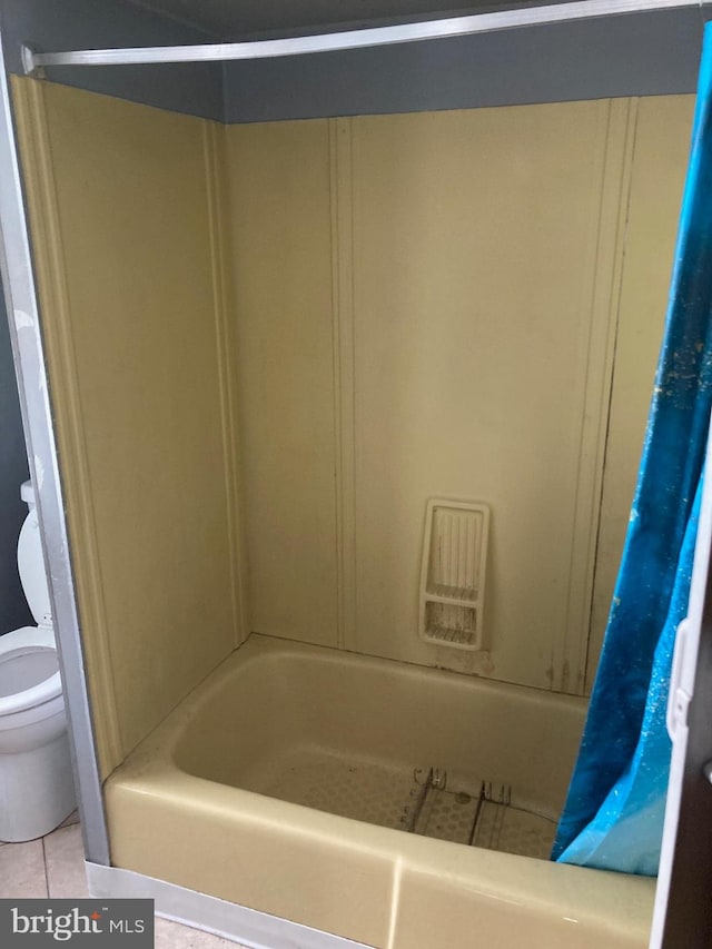 bathroom featuring shower / tub combo, toilet, and tile patterned floors