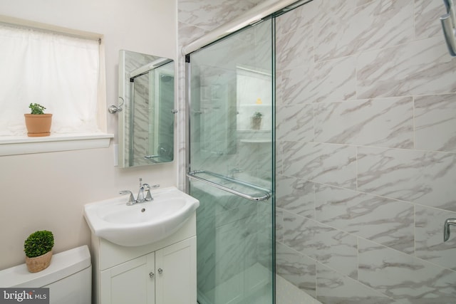 bathroom featuring walk in shower, vanity, toilet, and plenty of natural light