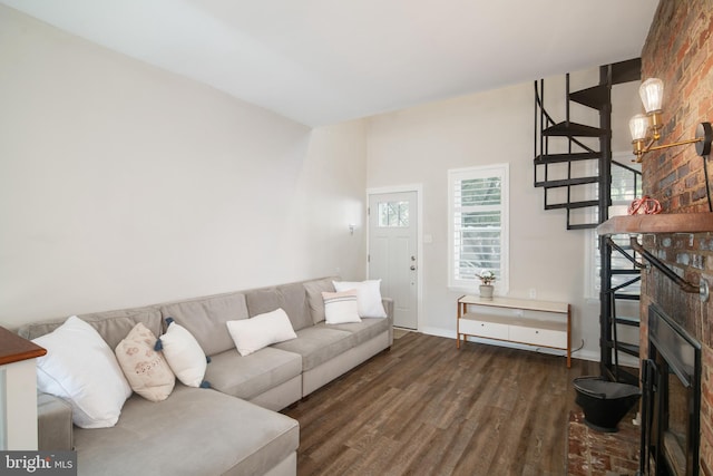 living room with dark hardwood / wood-style floors and a brick fireplace