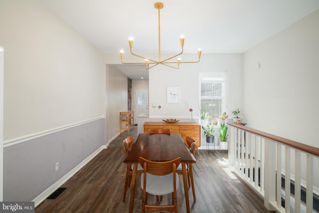 dining space with an inviting chandelier and dark wood-type flooring