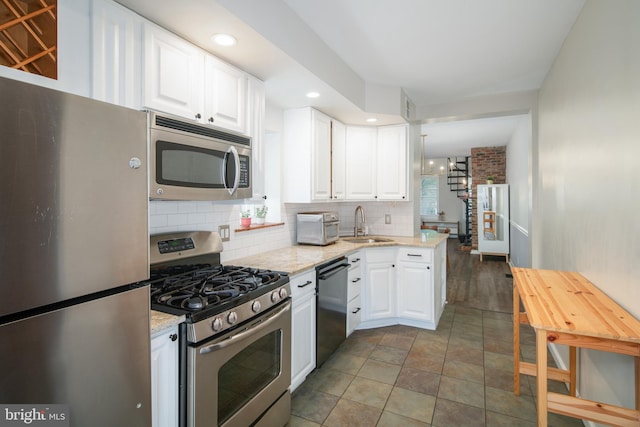 kitchen featuring white cabinetry, stainless steel appliances, and light stone counters