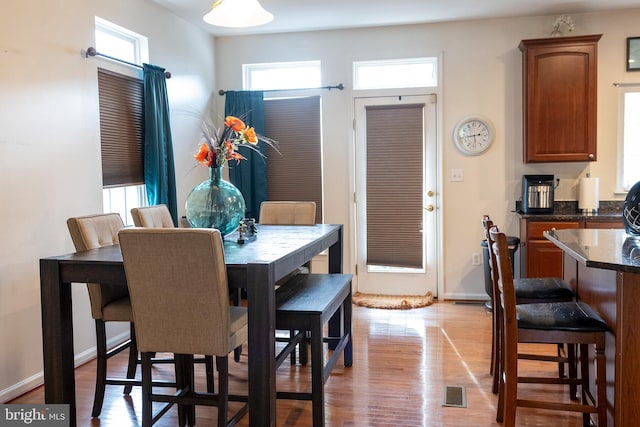 dining area with light hardwood / wood-style flooring and a healthy amount of sunlight