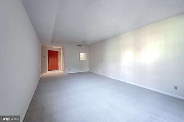 carpeted spare room featuring a textured ceiling