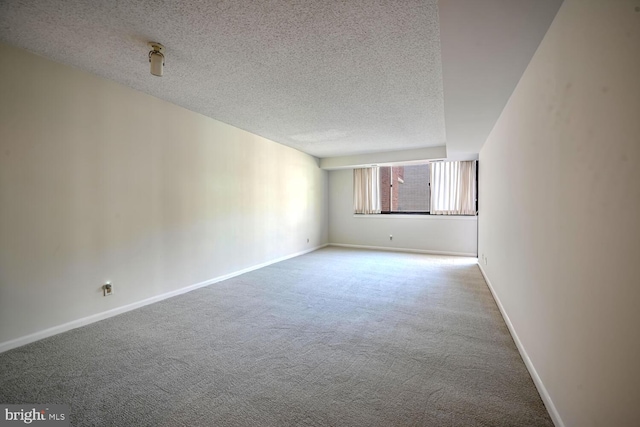 carpeted spare room featuring a textured ceiling