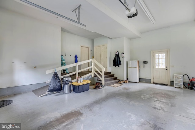 garage featuring a garage door opener and white refrigerator