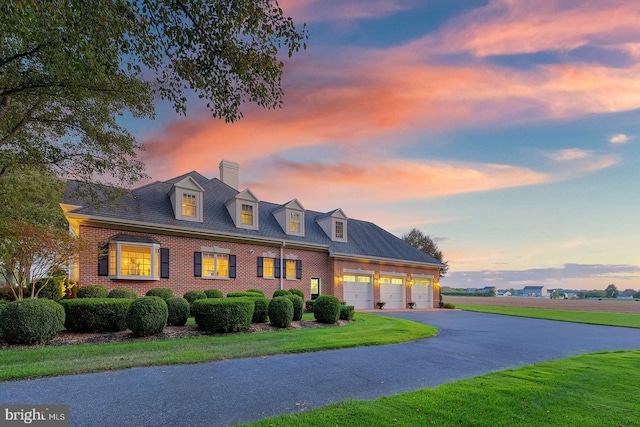 new england style home with a garage and a lawn