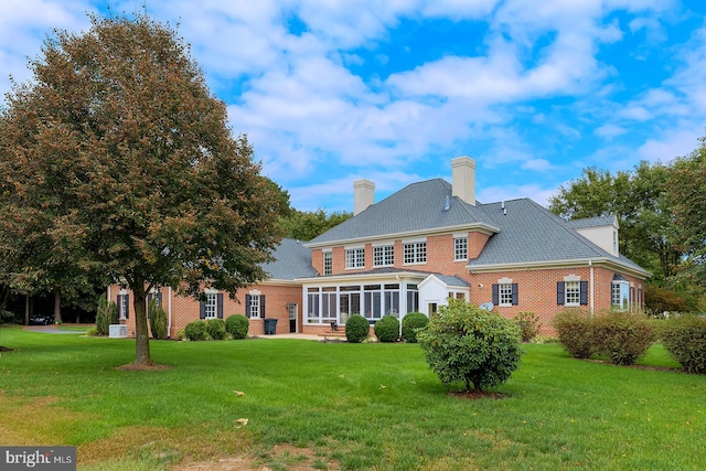 back of house featuring a yard and a sunroom