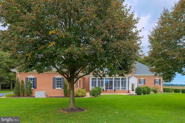 view of front facade featuring a front lawn and a sunroom