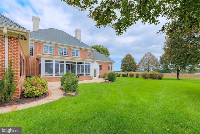20459 Troyer Ln, Lincoln, DE 19960 - rear view of property featuring brick siding, a patio, a sunroom, and a lawn