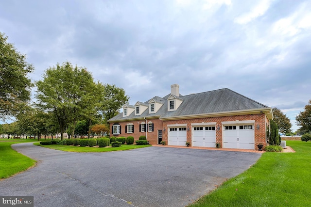 cape cod home with a front lawn and a garage