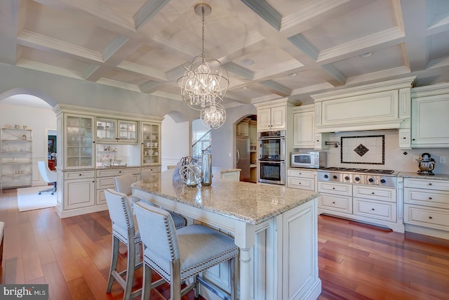 kitchen featuring dark hardwood / wood-style flooring, a notable chandelier, pendant lighting, and stainless steel appliances