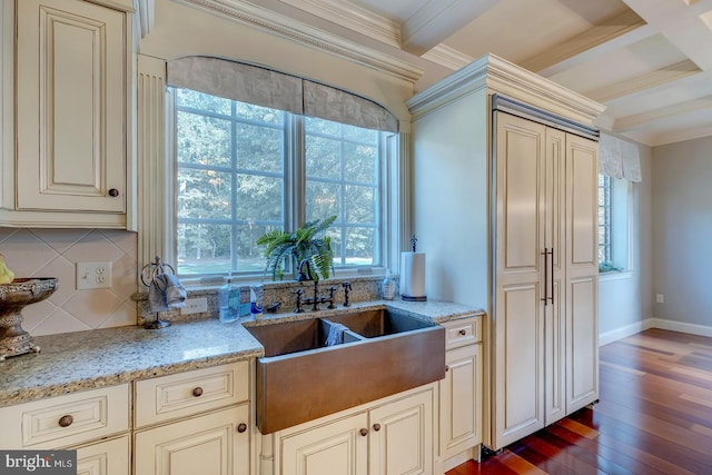 kitchen with a healthy amount of sunlight, ornamental molding, cream cabinetry, and hardwood / wood-style floors