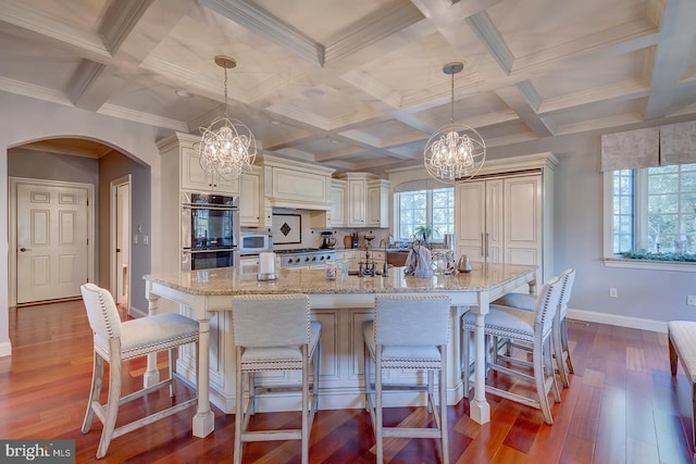 kitchen featuring appliances with stainless steel finishes, pendant lighting, and hardwood / wood-style floors