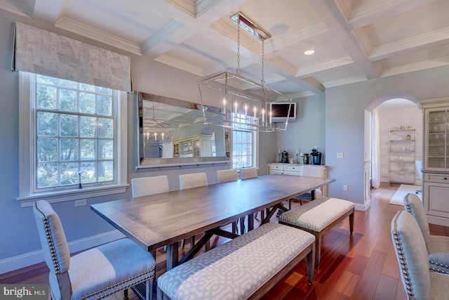 dining space with coffered ceiling, beam ceiling, hardwood / wood-style flooring, ornamental molding, and an inviting chandelier