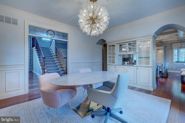 dining space with beam ceiling, ornamental molding, dark hardwood / wood-style flooring, and a chandelier