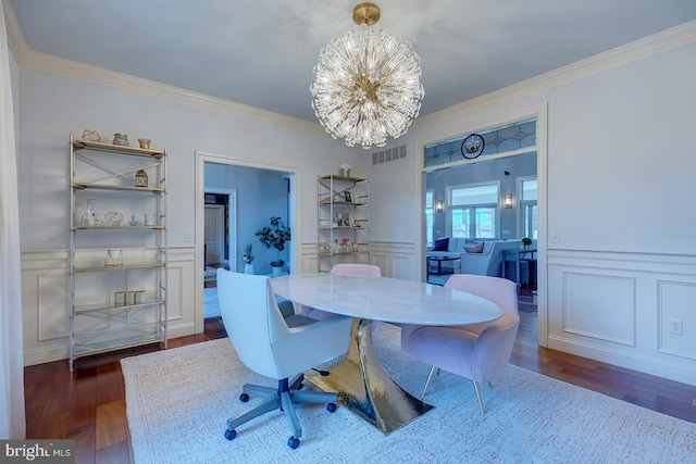 dining area with crown molding, dark hardwood / wood-style floors, and a chandelier