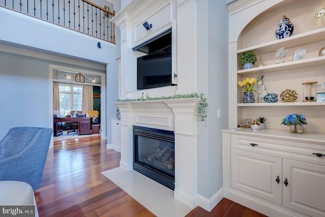 living room with a towering ceiling and dark hardwood / wood-style floors