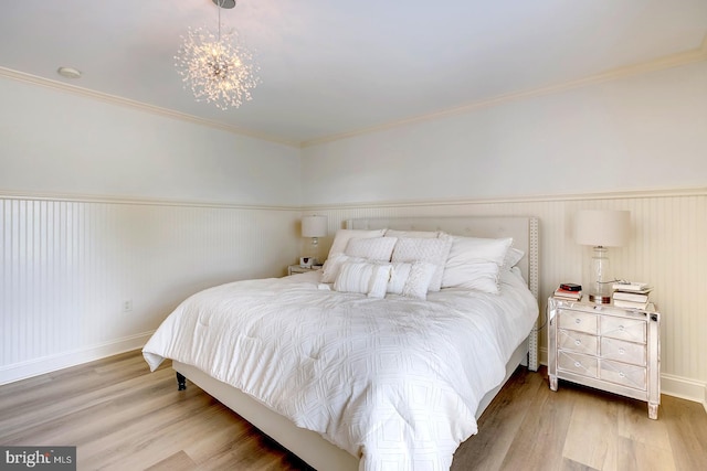 bedroom with crown molding, an inviting chandelier, and hardwood / wood-style floors