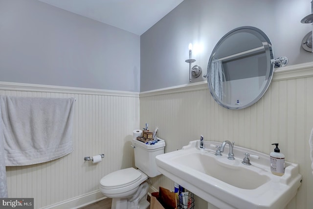 bathroom featuring sink, vaulted ceiling, and toilet