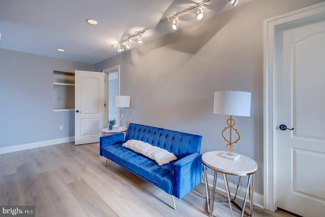 living area featuring hardwood / wood-style flooring and track lighting