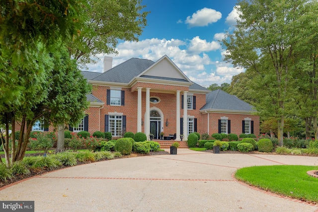 20459 Troyer Ln, Lincoln, DE 19960 - neoclassical home featuring a chimney, a shingled roof, and brick siding