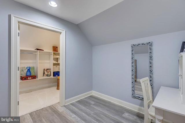 interior space with hardwood / wood-style floors and vaulted ceiling