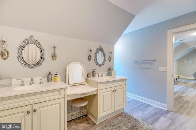 bathroom featuring vanity, vaulted ceiling, and hardwood / wood-style floors