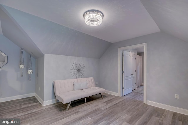 unfurnished room featuring lofted ceiling, a chandelier, and light hardwood / wood-style floors