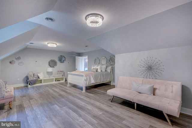 bedroom featuring vaulted ceiling and light wood-type flooring