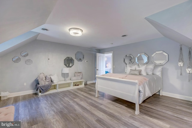 bedroom with hardwood / wood-style floors and vaulted ceiling