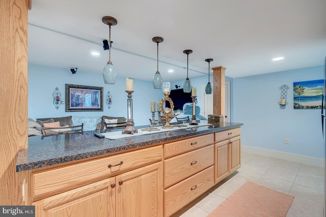 kitchen featuring kitchen peninsula, light brown cabinets, hanging light fixtures, and light tile patterned flooring