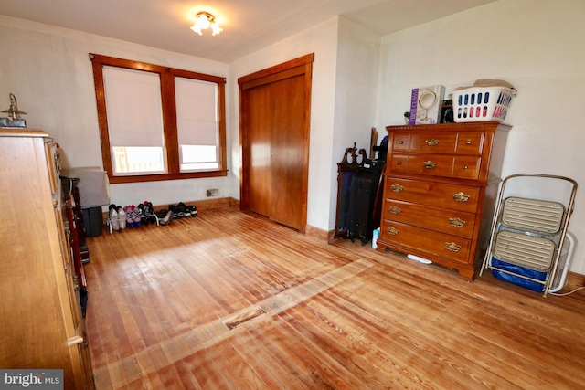 bedroom with light hardwood / wood-style floors and a closet