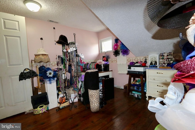 additional living space with a textured ceiling and dark wood-type flooring