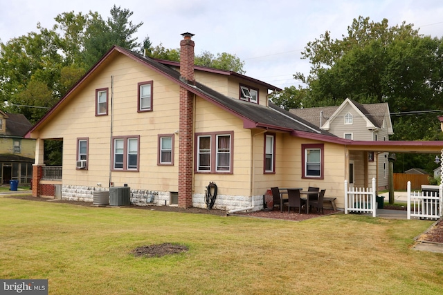 rear view of property with a lawn and central AC