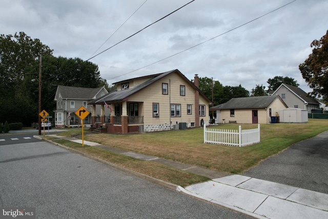 bungalow-style home featuring central air condition unit and a front yard