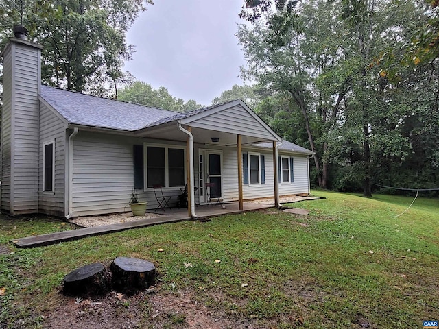 rear view of property with a yard and a patio area