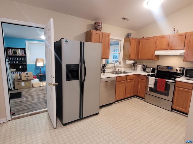 kitchen with stainless steel appliances, sink, and lofted ceiling