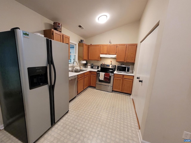 kitchen featuring vaulted ceiling, stainless steel appliances, and sink