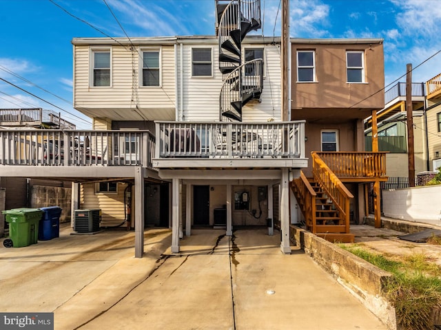 back of house featuring a wooden deck and central AC unit