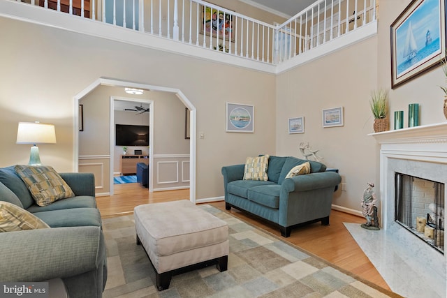 living room featuring hardwood / wood-style flooring, a towering ceiling, and a fireplace