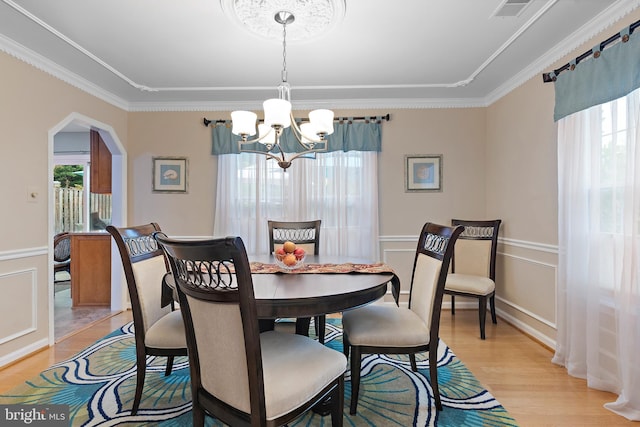 dining space with crown molding, a wealth of natural light, and light hardwood / wood-style flooring