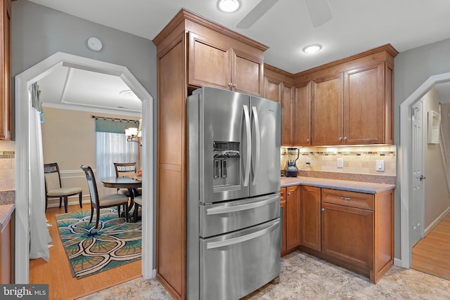 kitchen featuring stainless steel refrigerator with ice dispenser, ceiling fan, and decorative backsplash