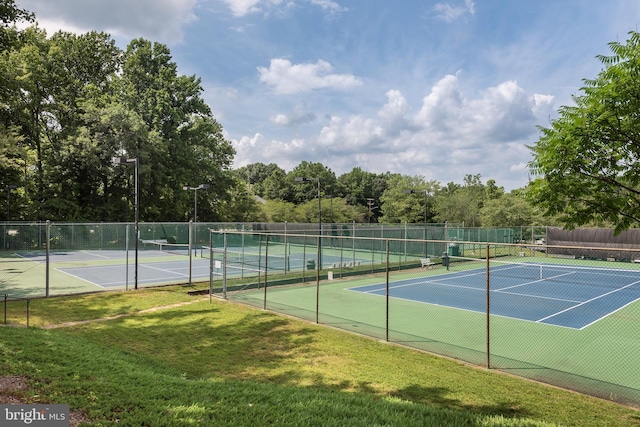 view of tennis court with a lawn