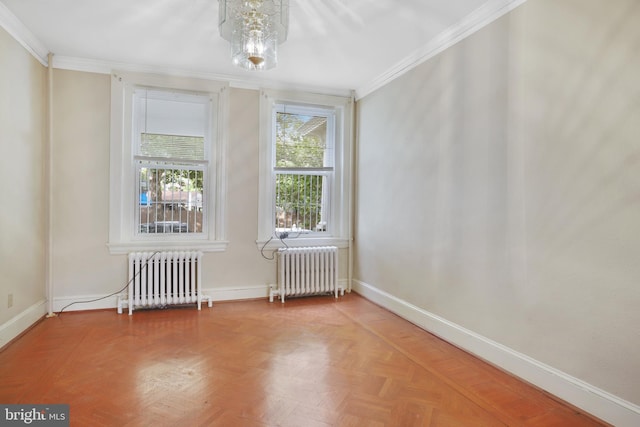 unfurnished room featuring an inviting chandelier, parquet flooring, ornamental molding, and radiator heating unit