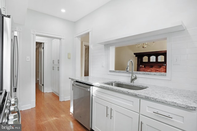 kitchen featuring stainless steel appliances, light wood-type flooring, sink, and white cabinetry