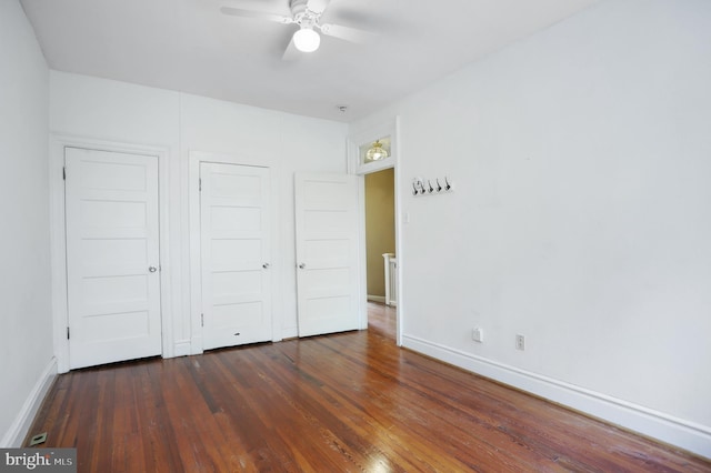 unfurnished bedroom featuring ceiling fan and dark hardwood / wood-style floors