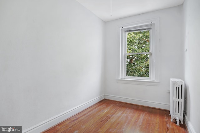 empty room featuring light hardwood / wood-style floors and radiator heating unit