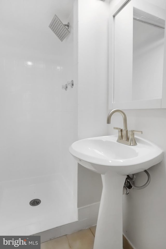 bathroom featuring sink, tile patterned floors, and tiled shower